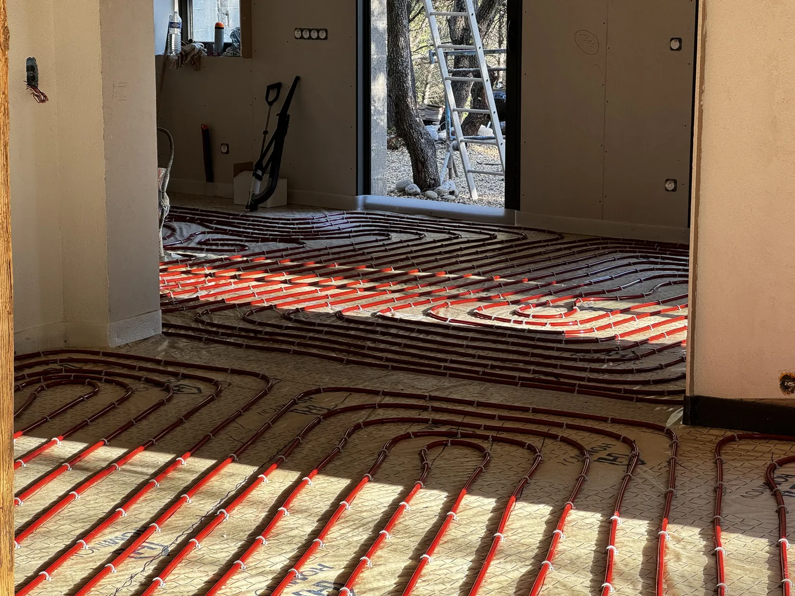Boucles de plancher chauffant dans une maison ensoleillée