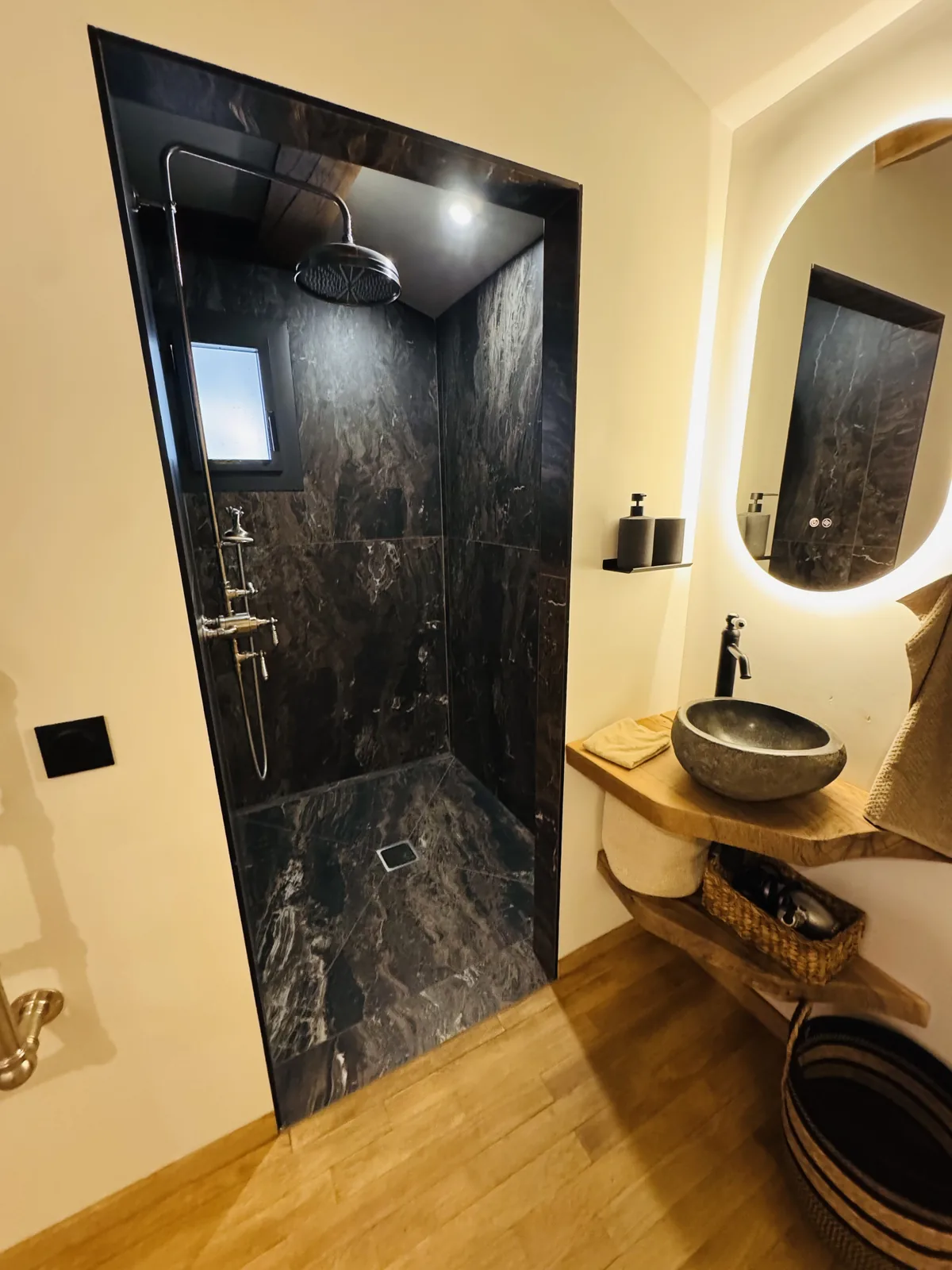 Salle de bains avec douche noire et meuble vasque en bois
